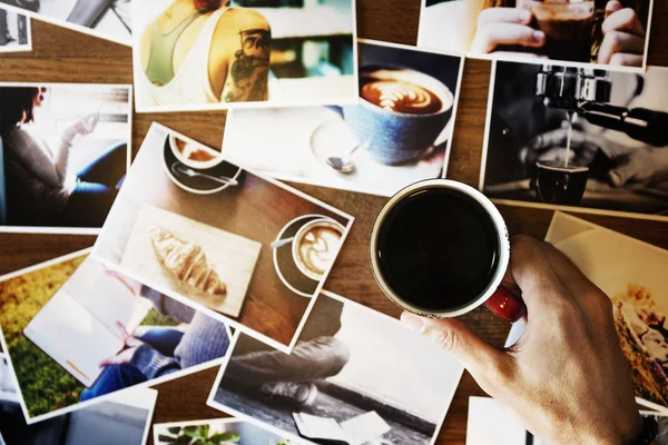 Person Mit Tasse Kaffee Sitzt Holztisch Voller Fotokarten — Stockfoto