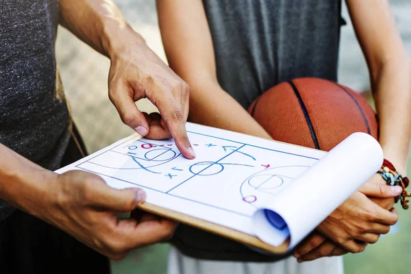 Esportista ensinando menino para jogar basquete — Fotografia de Stock