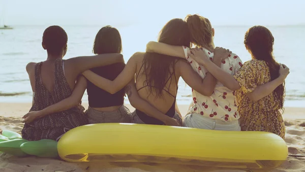 Группа различных женщин, сидящих на пляже вместе — стоковое фото