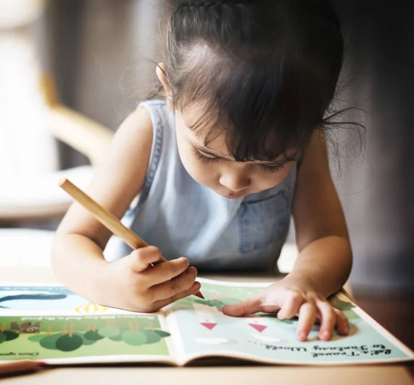 Девушка рисует на раскраске — стоковое фото