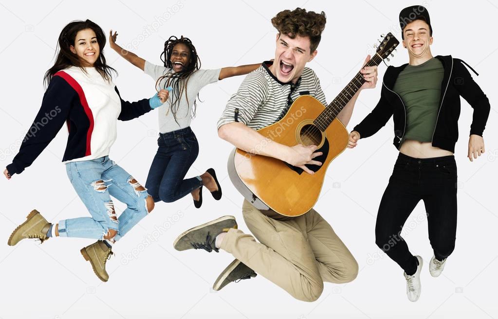 Diverse group of teenagers jumping and looking at camera isolated on white