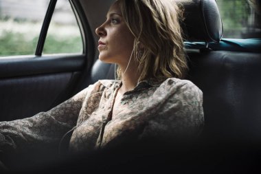 Takside oturan ve penceresine bakarak sarışın kadın