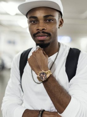 moda ciddi Afrika adamla beyaz kap ve t-shirt kameraya bakıyor yandan altın izle 