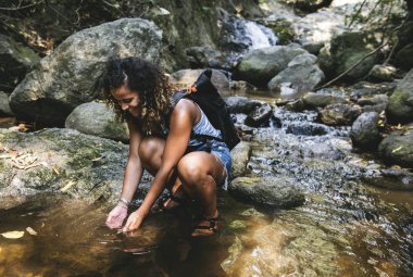 Afrikalı kadın backpacker creek elinden su tespit 