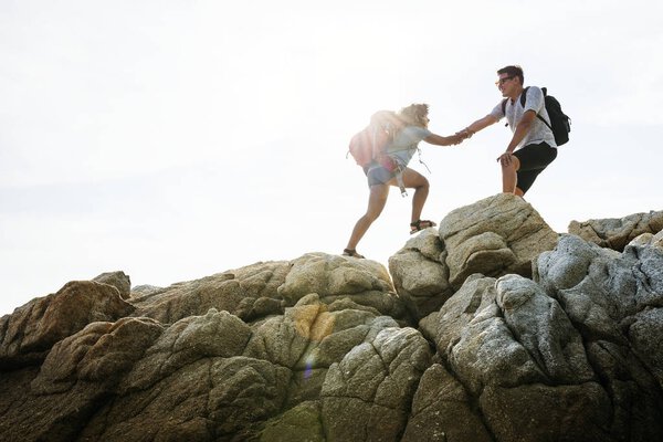 Молодая пара путешествует вместе по скалам
