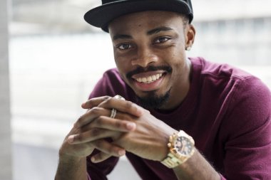 Afrika adam altın izle ile şapkalı yandan, gülümseyen ve kameraya bakarak moda  