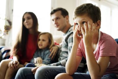 Beyaz aile kanepede oturan ve oturma odasında Tv arıyorum