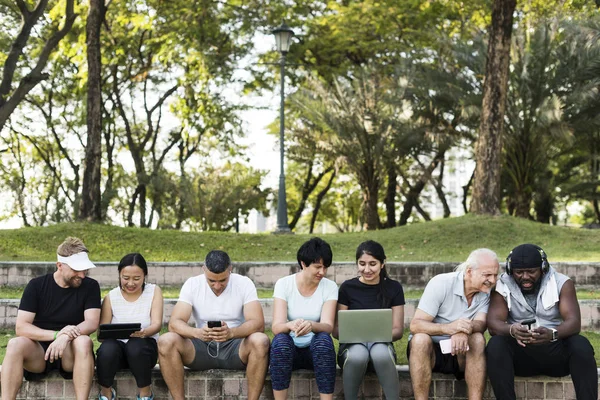 Grupo Personas Multiétnicas Que Utilizan Dispositivos Digitales Parque —  Fotos de Stock