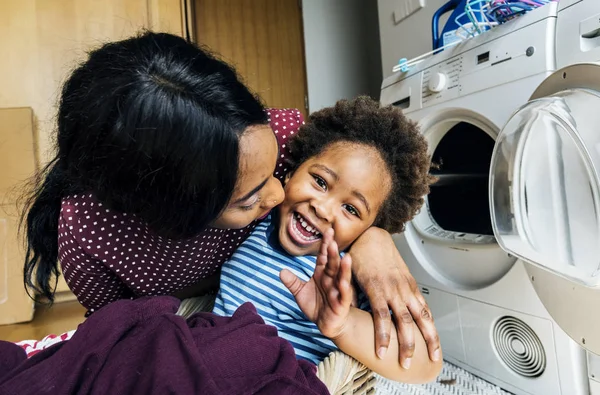 Afrikanska Mor Kyssar Lille Son Nära Tvättmaskin — Stockfoto