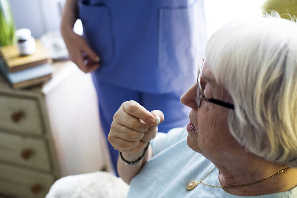 Senior woman taking pill  