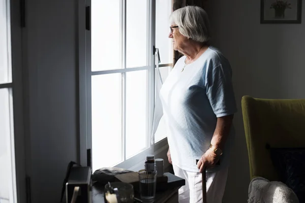 Senior Woman Standing Alone Window Home — Stock Photo, Image