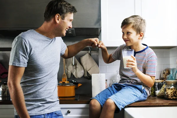 父子拳头在厨房里 男孩拿着一杯牛奶 — 图库照片