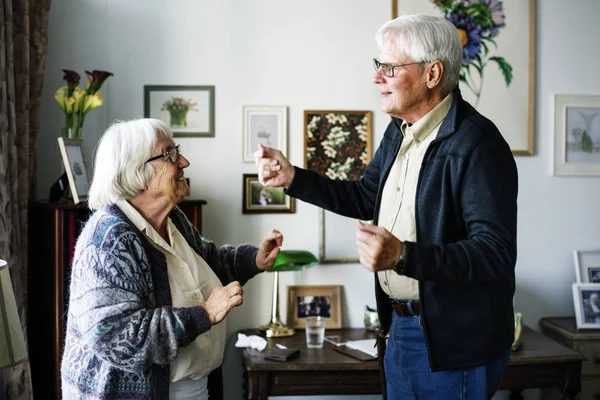 Senior couple dancing at home