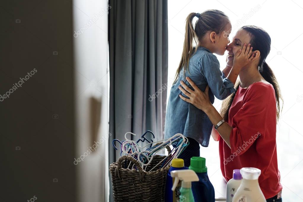 little girl kissing mother in nose