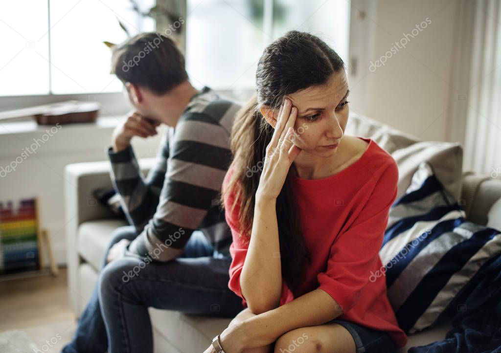 caucasian couple sitting on couch after quarrels 