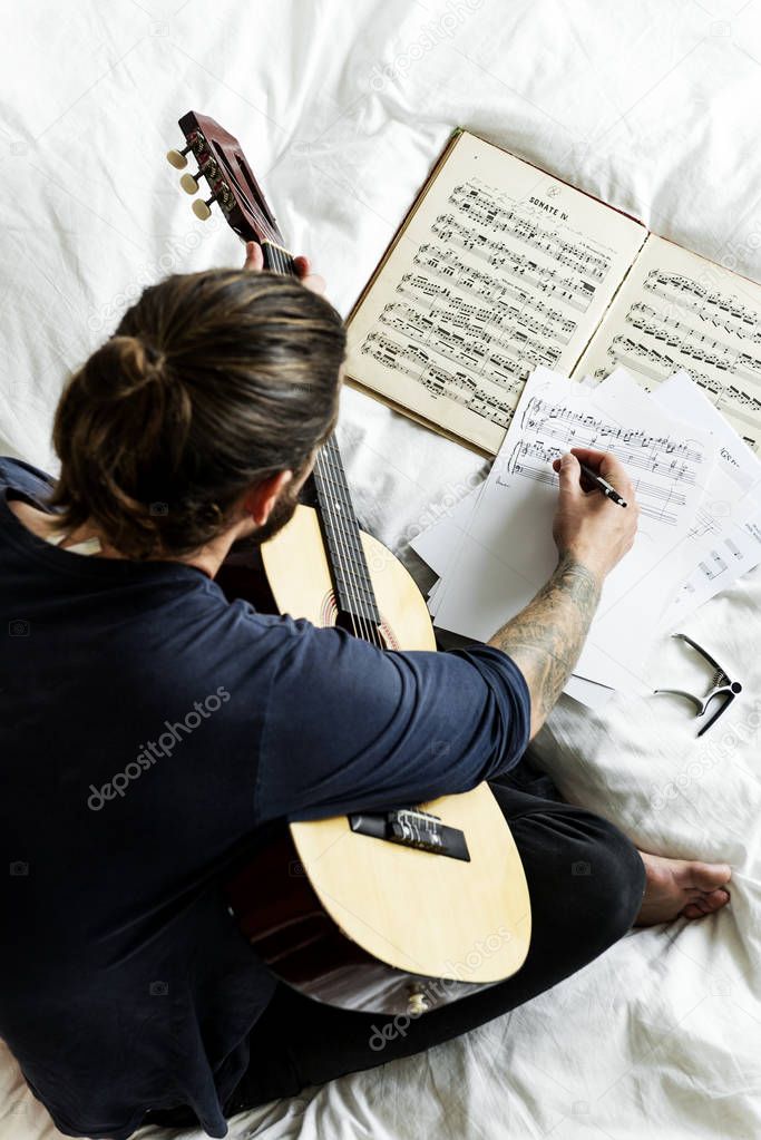 Man Practicing notes with guitar