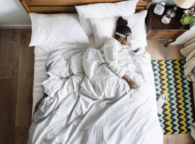 Afrikalı kadın yatakta uyku ile bir göz maskesi