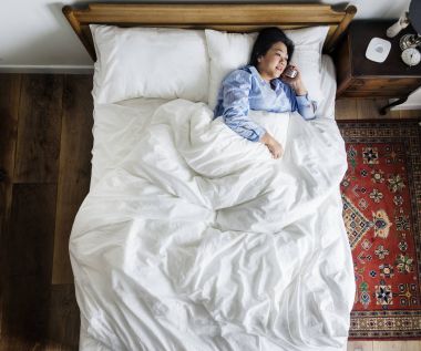 Kadın telefonda konuşurken yatakta