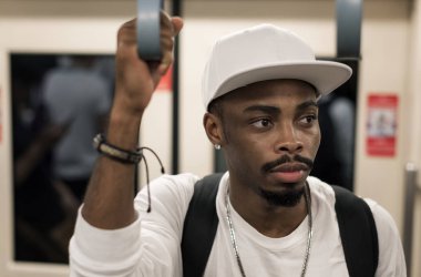 Trende, el için tanıtıcı tutarak sırt çantası ile Afrika adam