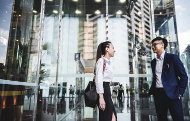 Asya iş adamları yakınındaki ofis binası girişinde tartışıyor