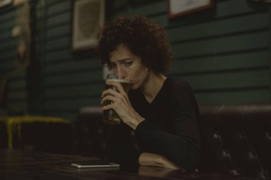 Bira içme ve hareket eden telefon için masaya seyir kadın çubuk