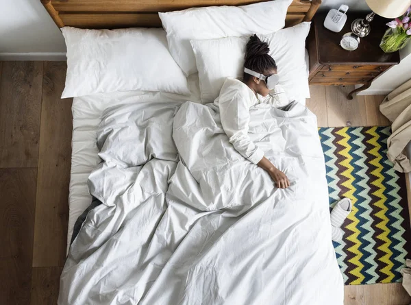 Afrikalı kadın yatakta uyku ile bir göz maskesi