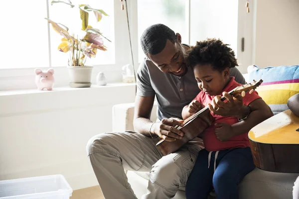 非洲父亲教儿子弹奏夏威夷琴 — 图库照片