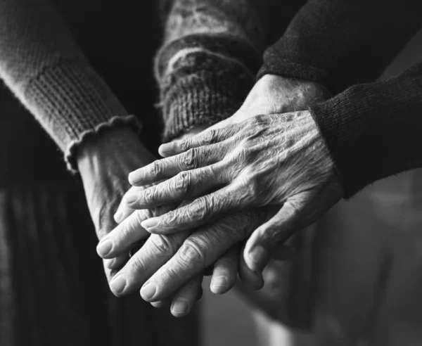 Closeup of hands of group of elderly people, black and white