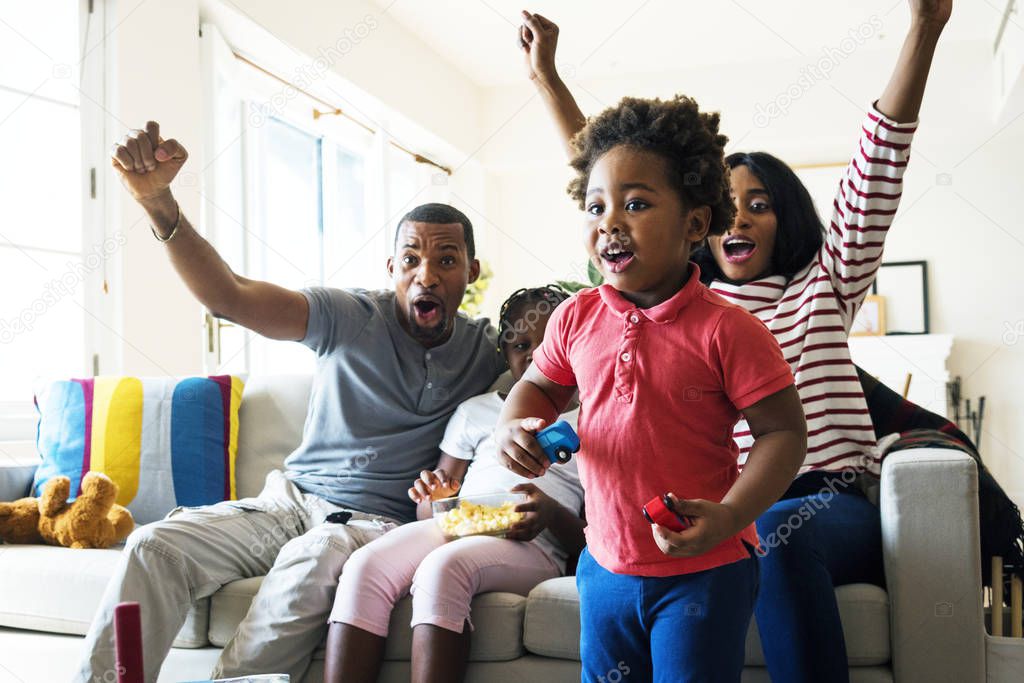 African family looking TV in living room