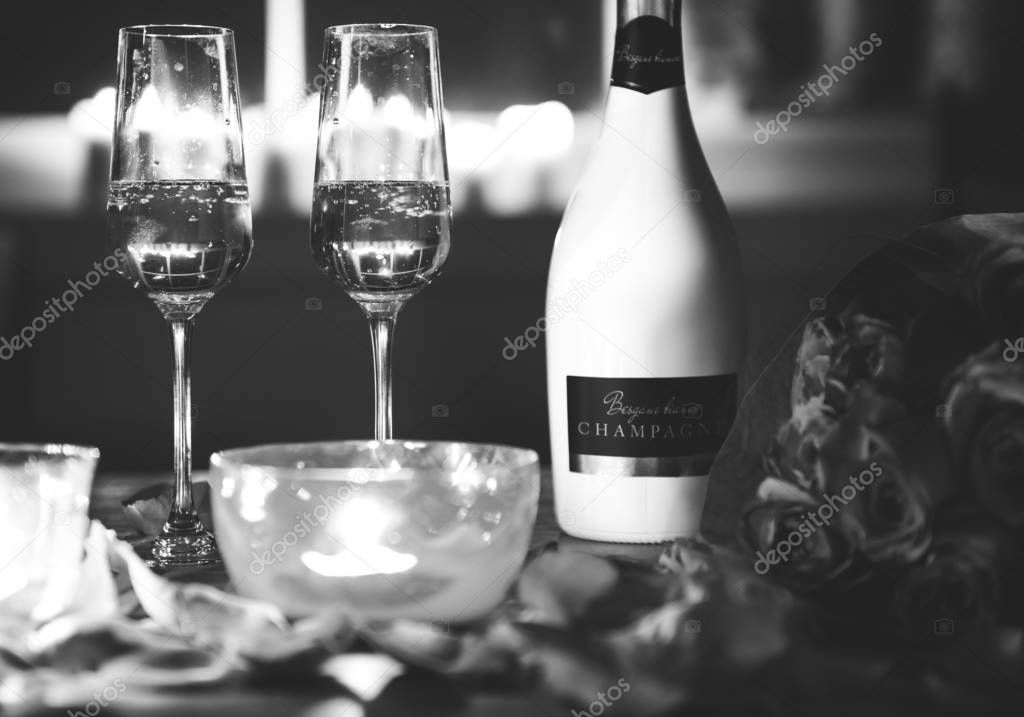 two glasses and bottle of wine at table for Valentines celebration, black and white