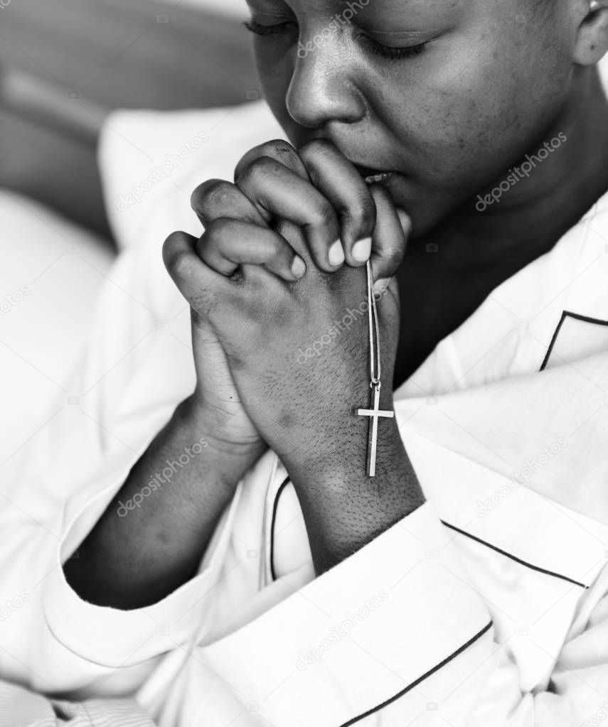 African woman praying in bed