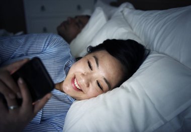 Telefonunuzun ve bir yatakta Asyalı kadın