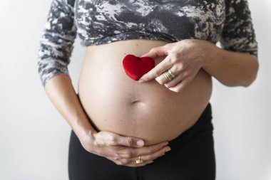 Onun bebek carpma önünde bir kalp tutan hamile kadın