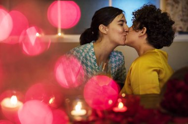 Lesbian couple kissing during dinner clipart