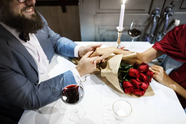 Чоловік Дарує Букет Червоної Троянди Жінці Під Час Романтичної Вечері — стокове фото