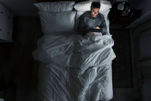 Άντρας Στο Κρεβάτι Χρησιμοποιώντας Ψηφιακό Tablet — Φωτογραφία Αρχείου