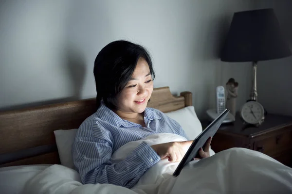Aziatische Vrouw Met Behulp Van Een Tablet Bed — Stockfoto