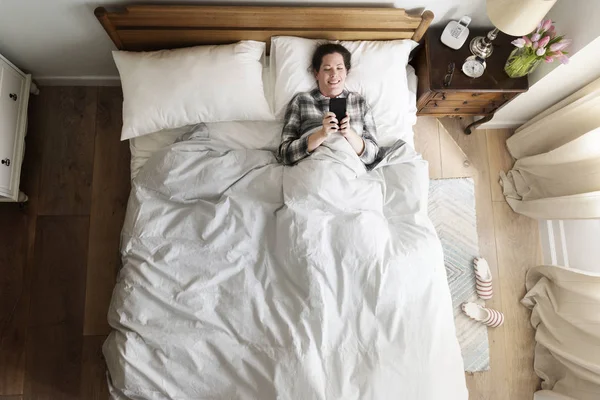 Leende Kaukasisk Kvinna Sängen Med Mobiltelefon — Stockfoto