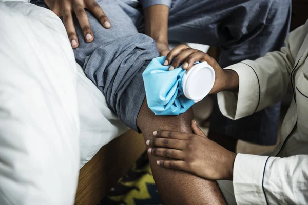 African Girlfriend Treating Boyfriend Injured Leg — Stock Photo, Image