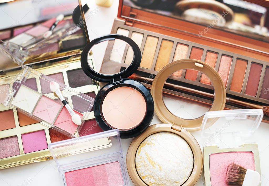 Various makeup products on white table