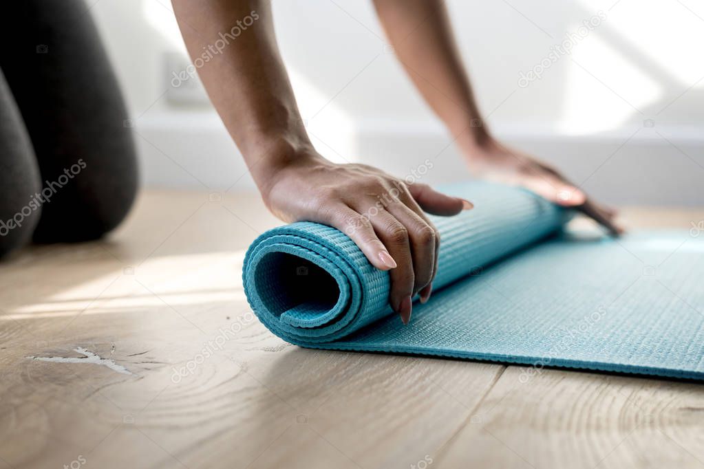 Woman rolling yoga mat, original photoset