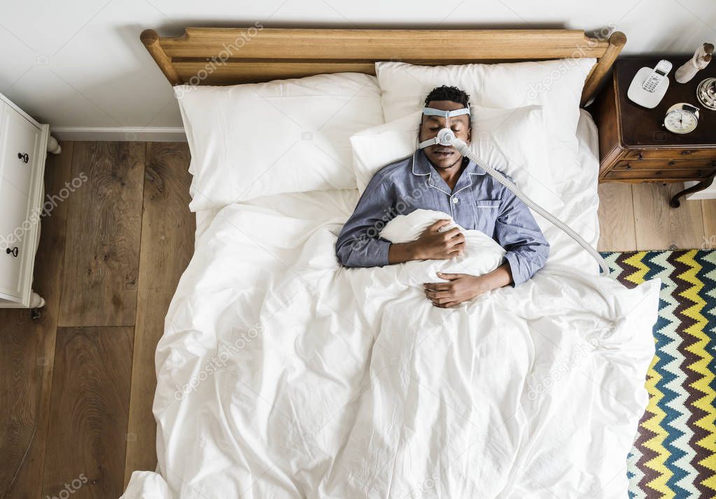 top view Man sleeping with an anti-snoring mask