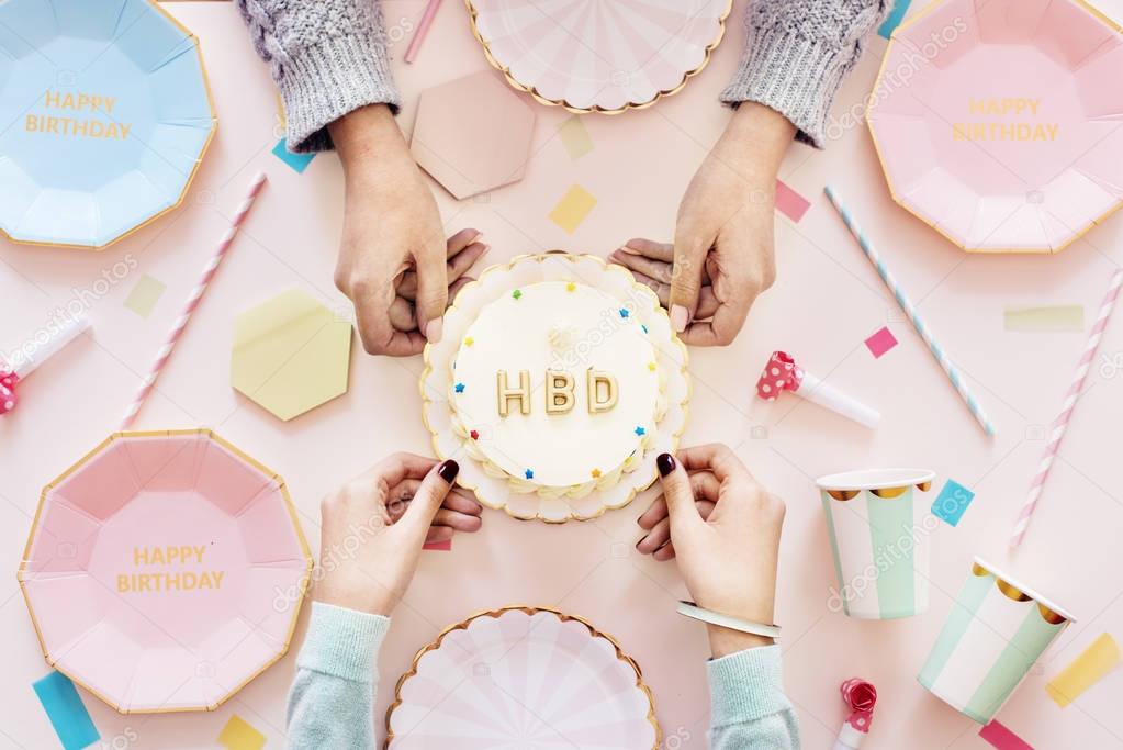 Hands of people holding cake for celebrating birthday