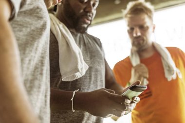 Fitness salonunda Smartphone kullanan adam