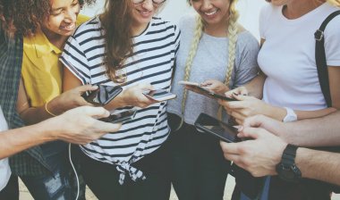 Genç Yetişkin arkadaşlar akıllı telefonlar birlikte kullanarak açık havada Gençlik Kültür kavramı