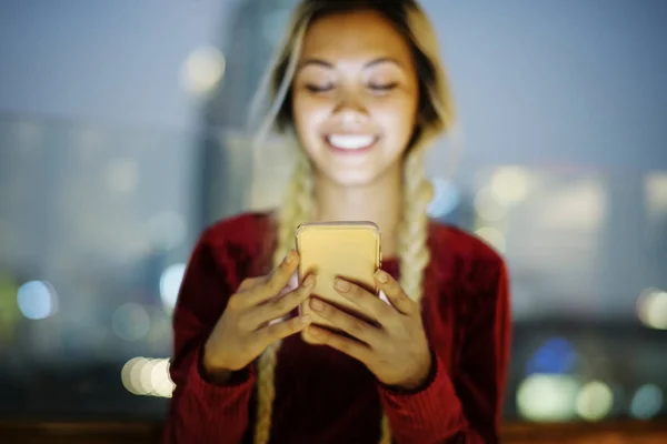 Akşam Cityscape Bir Akıllı Telefon Kullanan Gülümseyen Genç Kadın — Stok fotoğraf