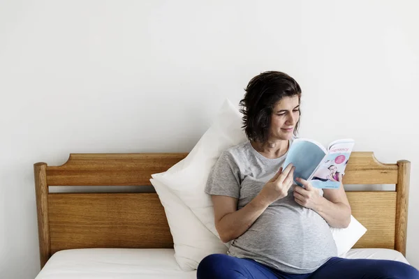 Беременная Женщина Читает Книгу Постели — стоковое фото