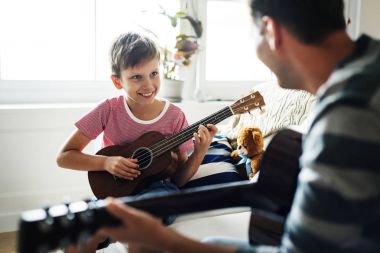 Genç çocuk gitar baba ile oynamak 