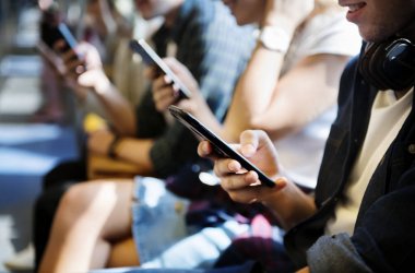 Akıllı telefonlar metroda kullanarak genç yetişkin arkadaş grubu