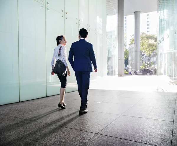 歩きながら議論するアジアのビジネス人々 の背面図 — ストック写真